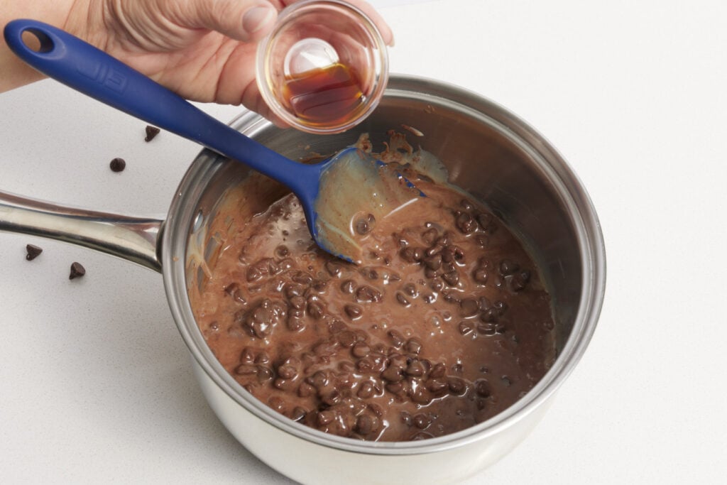 Adding vanilla extract to the chocolate chips and sweetened condensed milk